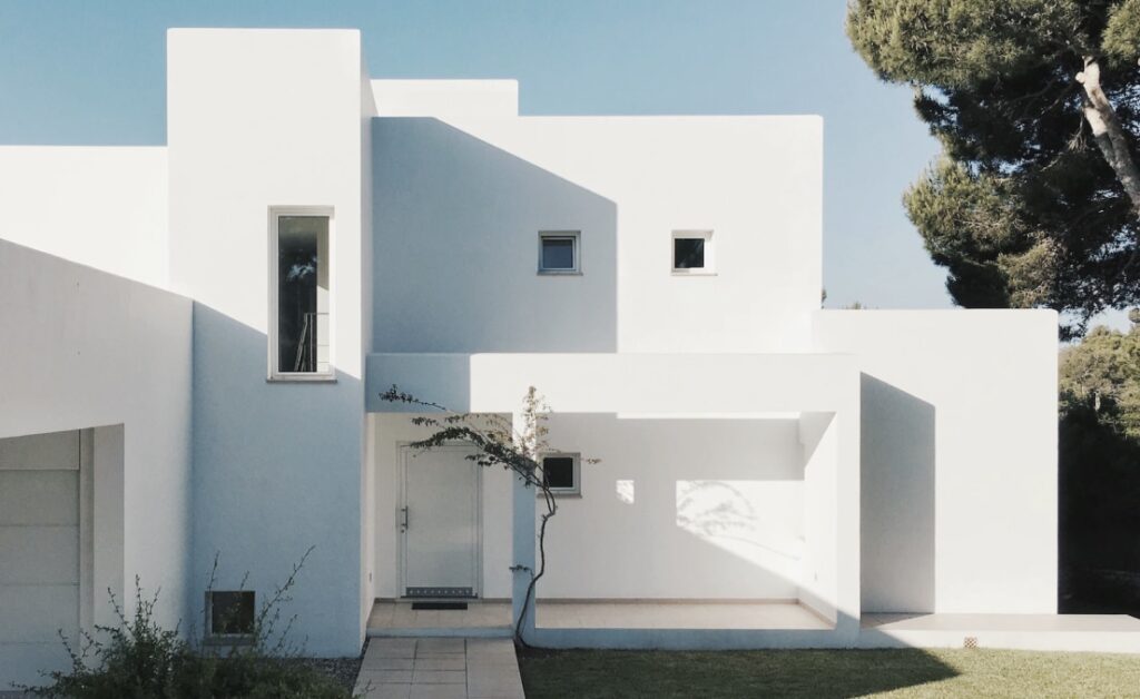 Casa moderna minimalista con pareti bianche e finestre geometriche.